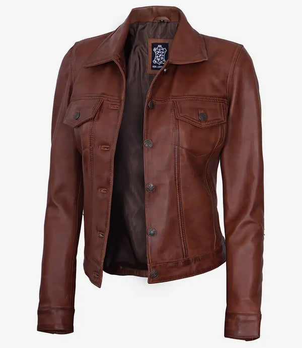 A cognac brown leather trucker jacket with a shirt collar, buttoned front closure, and multiple pockets.
